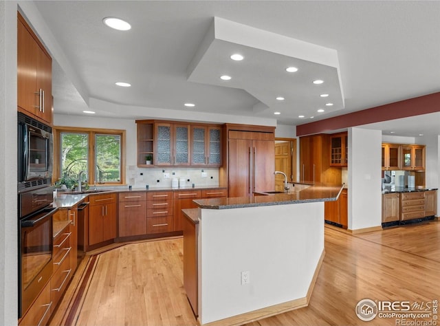 560 Northstar Ct, Boulder, CO 80304 - kitchen with black appliances, a tray ceiling, brown cabinets, a sink, and recessed lighting