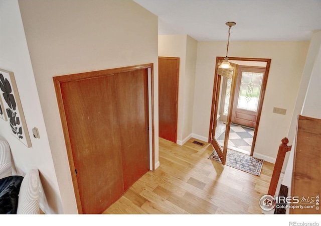 foyer entrance featuring light wood finished floors and baseboards