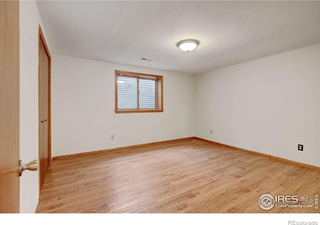 unfurnished room featuring light wood-type flooring and baseboards