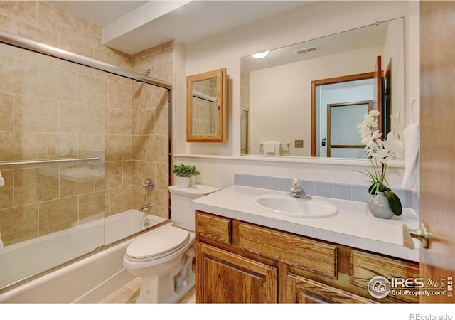 full bath with vanity, combined bath / shower with glass door, and toilet