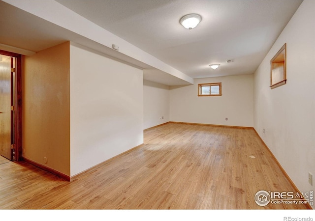 basement featuring light wood finished floors and baseboards