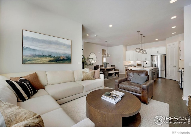 living room with dark wood-type flooring, recessed lighting, and a chandelier