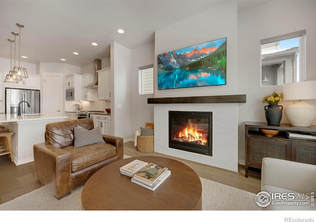 living room featuring wood finished floors, recessed lighting, and a fireplace