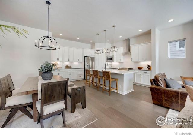 dining space featuring light wood-type flooring, recessed lighting, and a chandelier