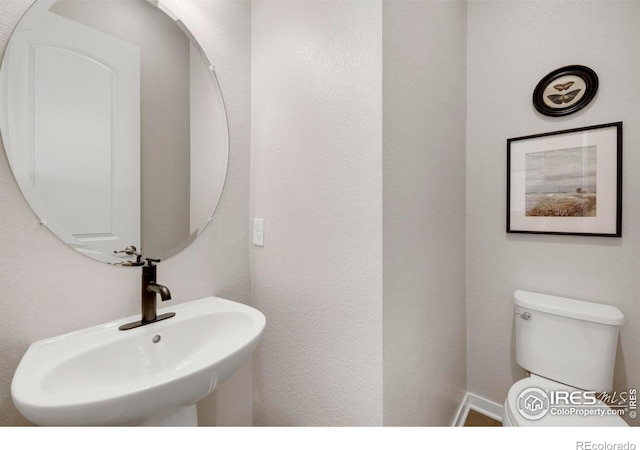 half bath featuring a sink and toilet