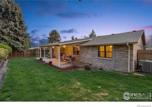 4880 Filbert Dr, Loveland, CO 80538 - back of property featuring brick siding, central AC, a patio, and a shingled roof