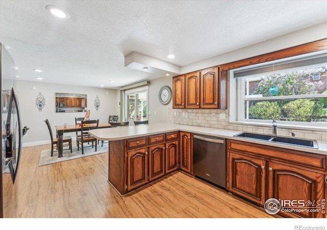 4880 Filbert Dr, Loveland, CO 80538 - kitchen with dishwasher, a peninsula, light wood-type flooring, light countertops, and a textured ceiling