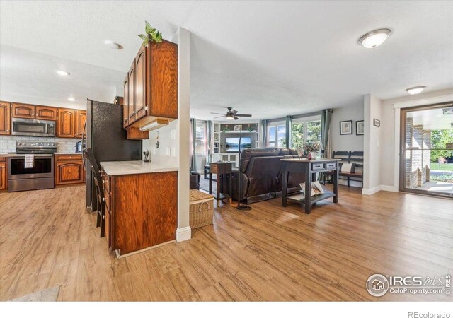 4880 Filbert Dr, Loveland, CO 80538 - kitchen with appliances with stainless steel finishes, light wood-style flooring, light countertops, and brown cabinets