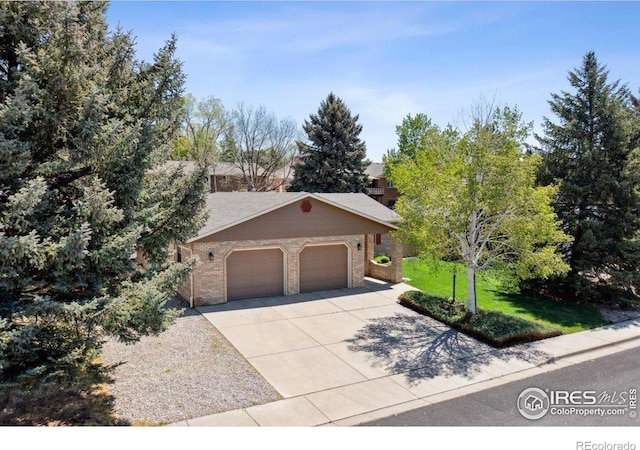 4880 Filbert Dr, Loveland, CO 80538 - view of front of home with brick siding, concrete driveway, a garage, and a front yard