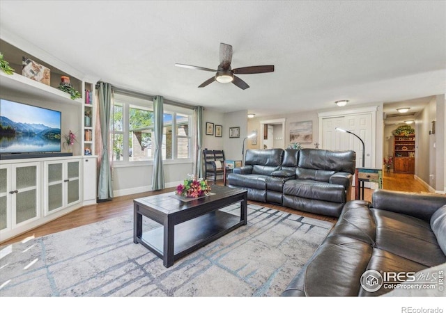 4880 Filbert Dr, Loveland, CO 80538 - living area featuring ceiling fan, baseboards, wood finished floors, and built in features