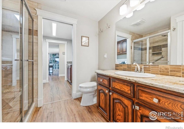 4880 Filbert Dr, Loveland, CO 80538 - full bathroom featuring a stall shower, vanity, wood finished floors, and toilet