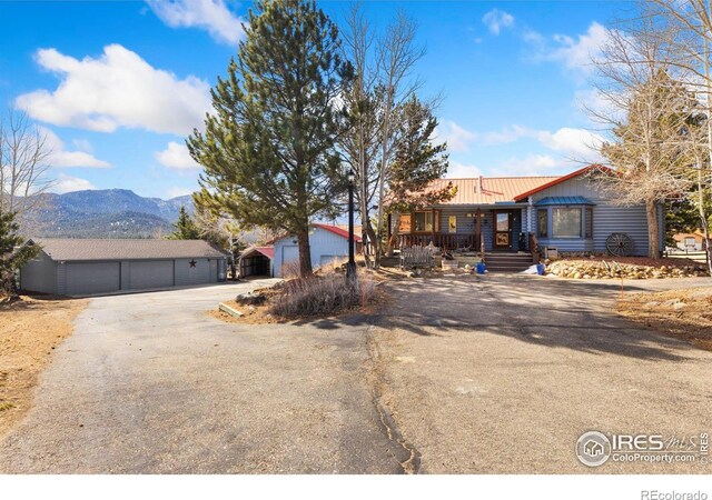 1810 N Ridge Ln, Estes Park, CO 80517 - view of front of house with a detached garage, a mountain view, metal roof, and an outbuilding
