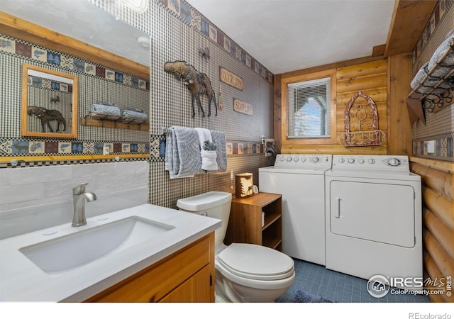 1810 N Ridge Ln, Estes Park, CO 80517 - bathroom featuring independent washer and dryer, rustic walls, toilet, tile patterned flooring, and vanity