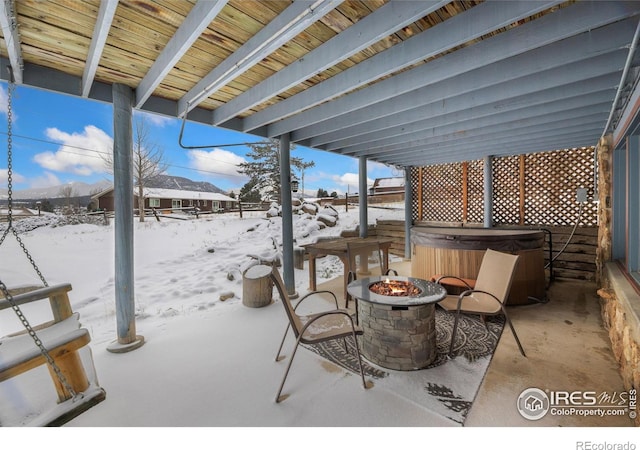 1810 N Ridge Ln, Estes Park, CO 80517 - snow covered patio with a hot tub, a fire pit, and fence