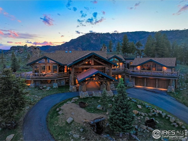 6553 Sunshine Canyon Dr, Boulder, CO 80302 - log-style house with curved driveway, a chimney, an attached garage, a mountain view, and a balcony