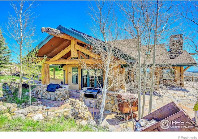 6553 Sunshine Canyon Dr, Boulder, CO 80302 - view of front of house with a chimney, a patio, and roof with shingles