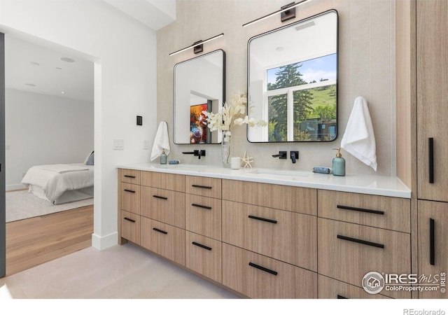2814 3rd St, Boulder, CO 80304 - ensuite bathroom featuring double vanity, wood finished floors, decorative backsplash, and baseboards