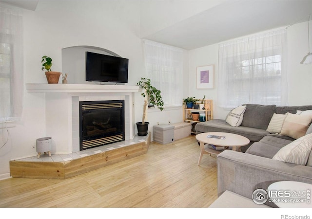 living area with wood finished floors and a tile fireplace