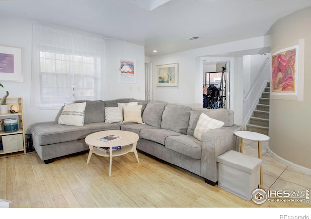 living area featuring stairway, light wood-type flooring, and recessed lighting