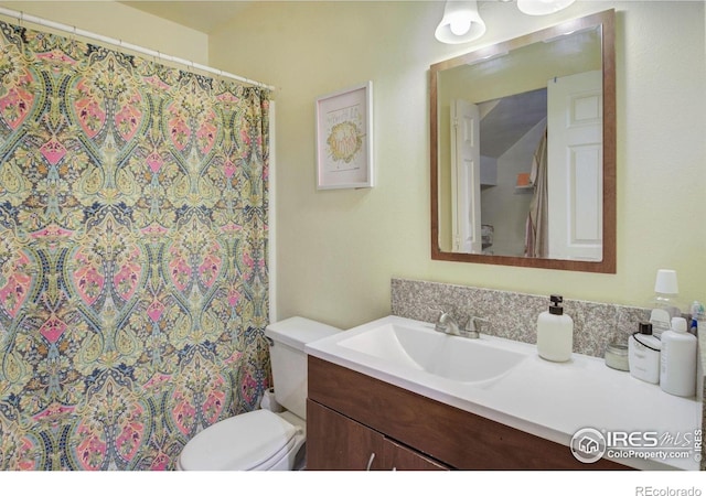 bathroom with toilet, vanity, and curtained shower