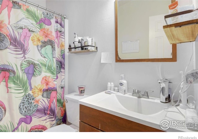 bathroom featuring vanity, curtained shower, and toilet
