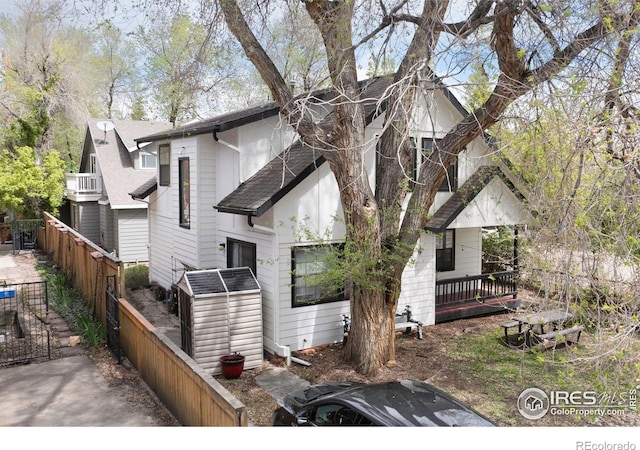 view of front of property with fence and roof with shingles