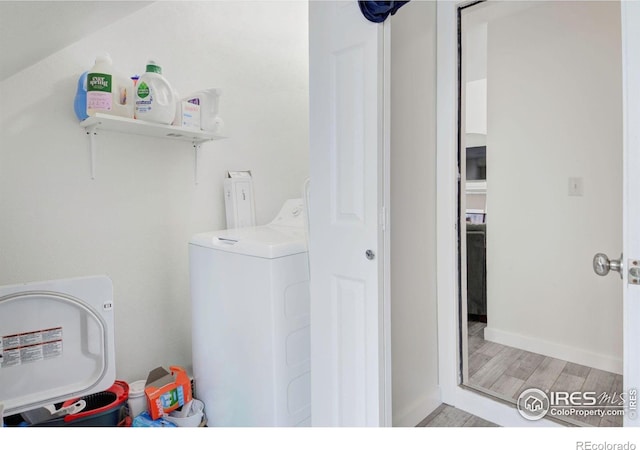 laundry room with washer / dryer, light wood finished floors, and baseboards