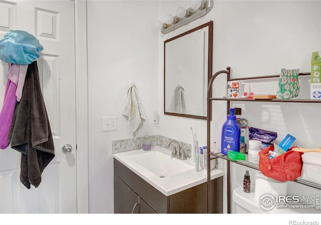 half bath featuring vanity and toilet