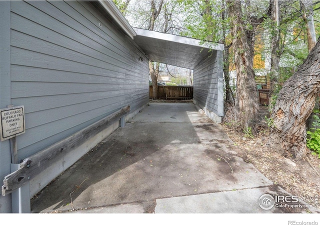 view of home's exterior with fence and a carport