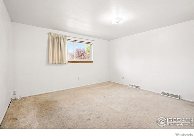 unfurnished room featuring carpet floors and baseboards