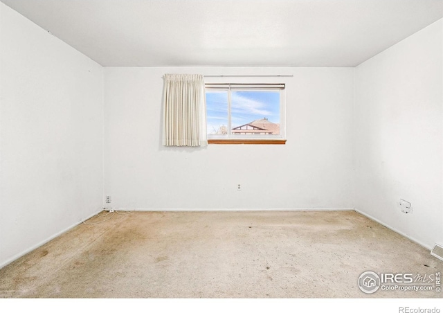 unfurnished room featuring carpet flooring and baseboards