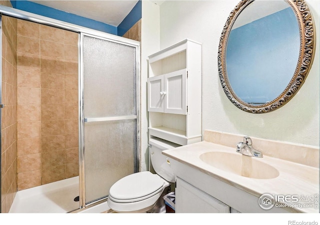 bathroom with a stall shower, vanity, and toilet