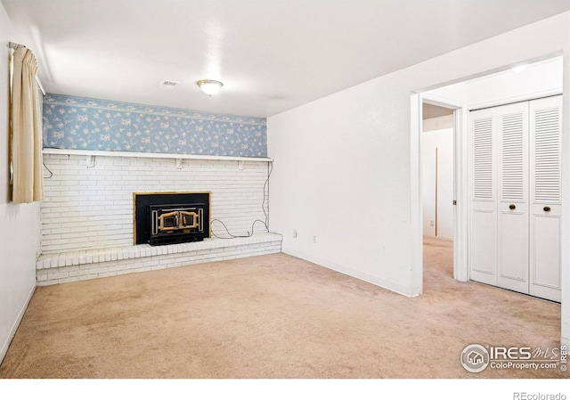 unfurnished living room with wallpapered walls, carpet floors, a brick fireplace, and baseboards