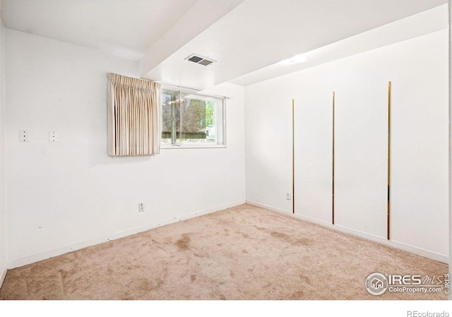 unfurnished room featuring carpet and baseboards