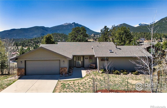 272 Solomon Dr, Estes Park, CO 80517 - ranch-style home with a mountain view, a garage, concrete driveway, and stone siding