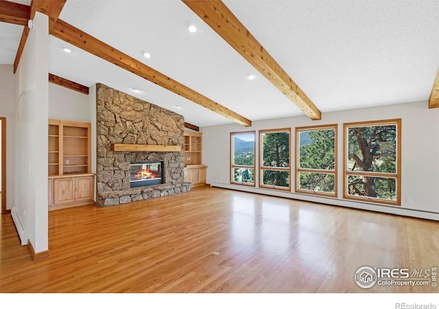 272 Solomon Dr, Estes Park, CO 80517 - unfurnished living room with wood finished floors, a baseboard heating unit, recessed lighting, beamed ceiling, and a stone fireplace