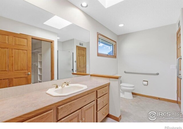 272 Solomon Dr, Estes Park, CO 80517 - full bath featuring a skylight, baseboards, toilet, vanity, and a shower with door