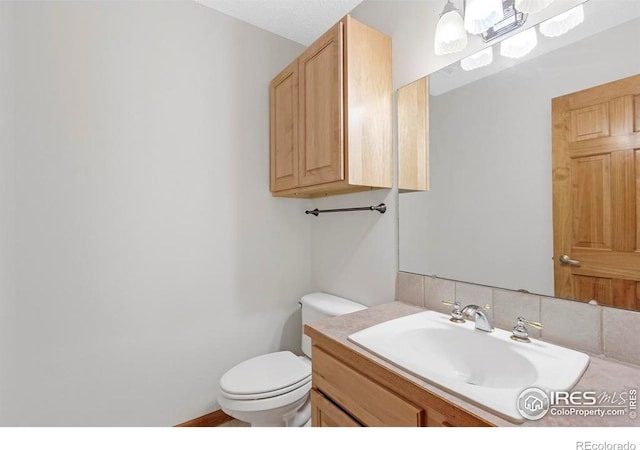 272 Solomon Dr, Estes Park, CO 80517 - half bath featuring toilet, vanity, and tasteful backsplash