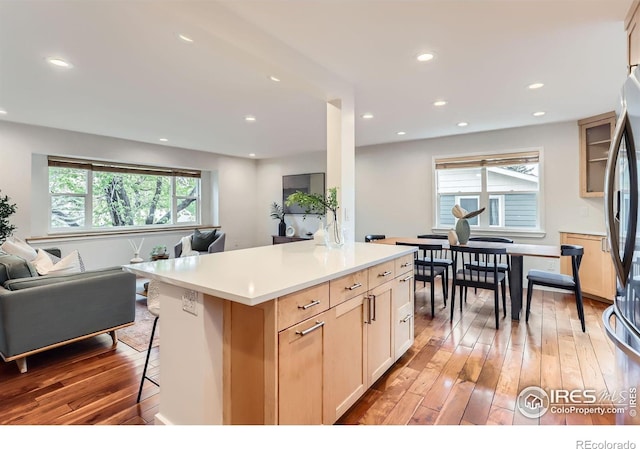 2550 Woodstock Pl, Boulder, CO 80305 - kitchen featuring open floor plan, light wood-style floors, a breakfast bar area, light countertops, and stainless steel refrigerator