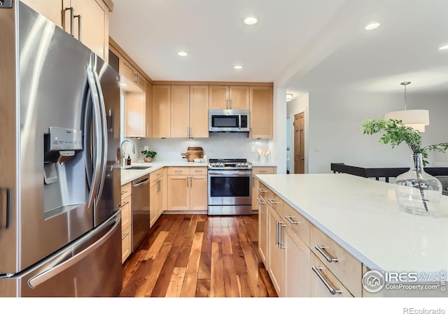 2550 Woodstock Pl, Boulder, CO 80305 - kitchen featuring stainless steel appliances, a sink, light brown cabinetry, dark wood-style flooring, and light countertops