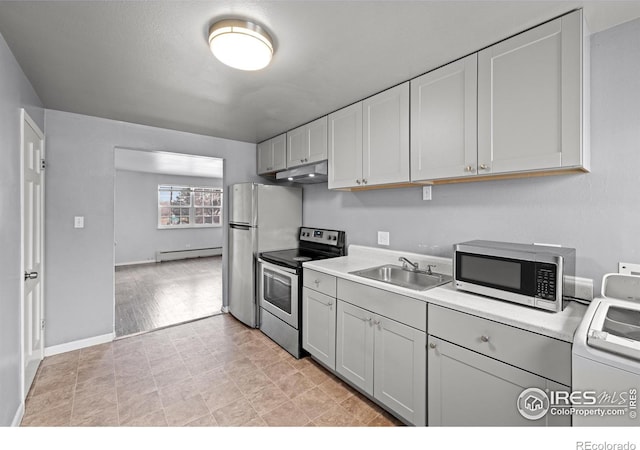 kitchen featuring appliances with stainless steel finishes, a sink, a baseboard radiator, and light countertops