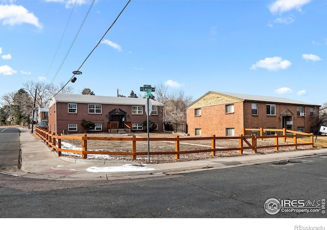 bi-level home featuring a fenced front yard and brick siding