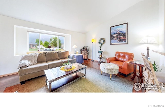 living room featuring wood finished floors, lofted ceiling, and baseboards