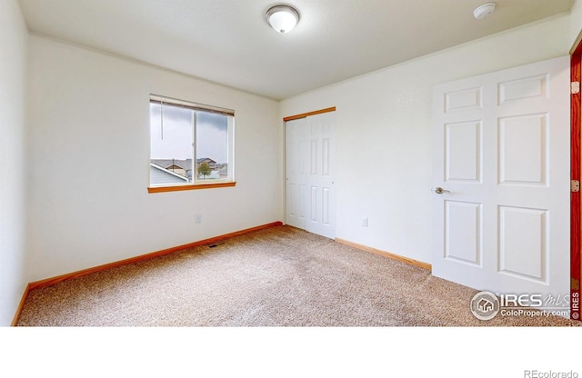 unfurnished bedroom with carpet floors, a closet, and baseboards