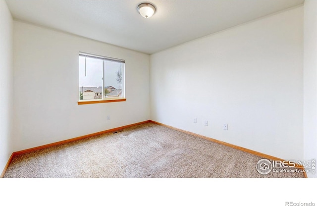 carpeted spare room with baseboards