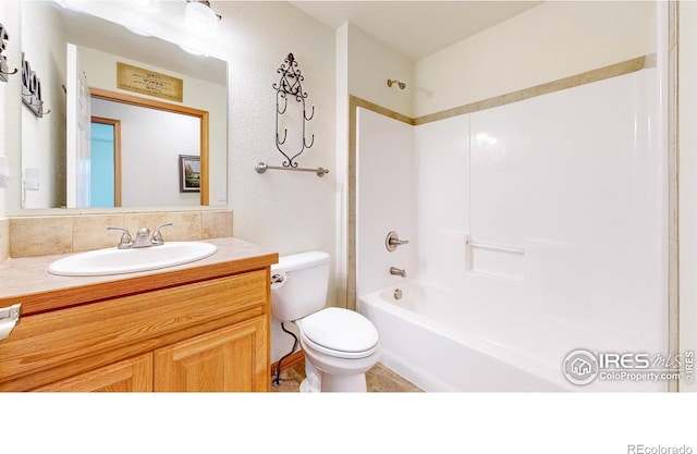 bathroom with toilet, vanity, and  shower combination