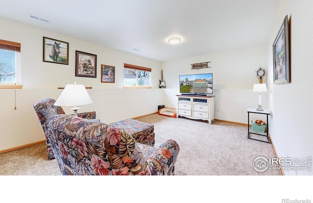 carpeted living area featuring baseboards