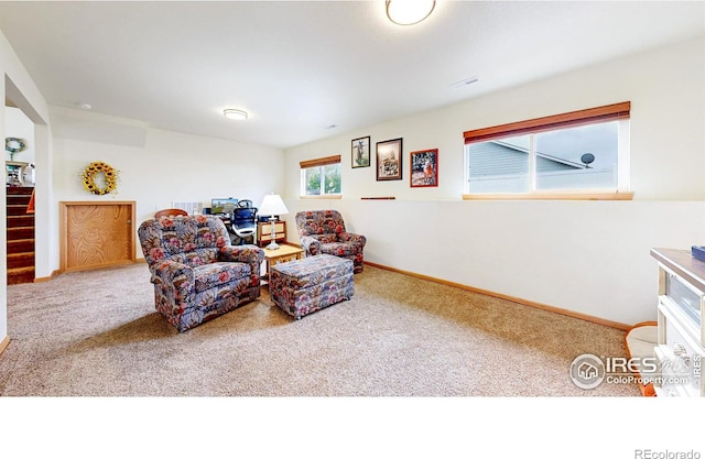 sitting room featuring carpet flooring, baseboards, and stairway