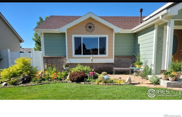 view of front of property with brick siding and roof with shingles
