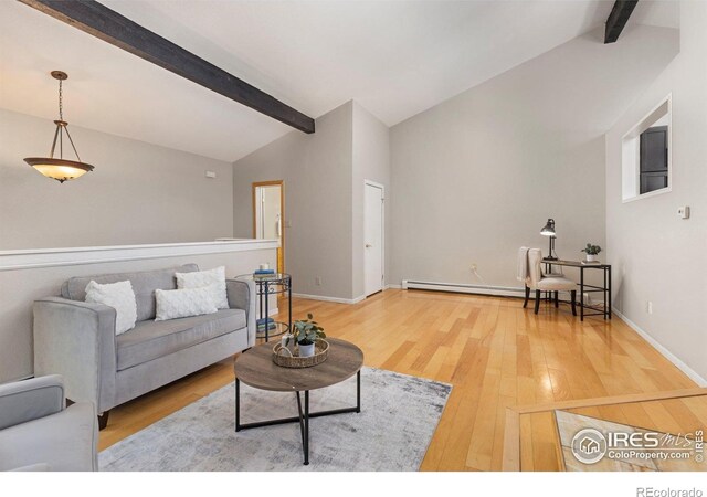living room with a baseboard heating unit, wood finished floors, and baseboards